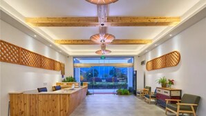Un espace d’accueil avec des poutres en bois au plafond, un comptoir d’accueil et des sièges.