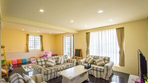 A living room with a sofa set, a coffee table, a television, and a chalkboard. - We Kids BB (Wujie)