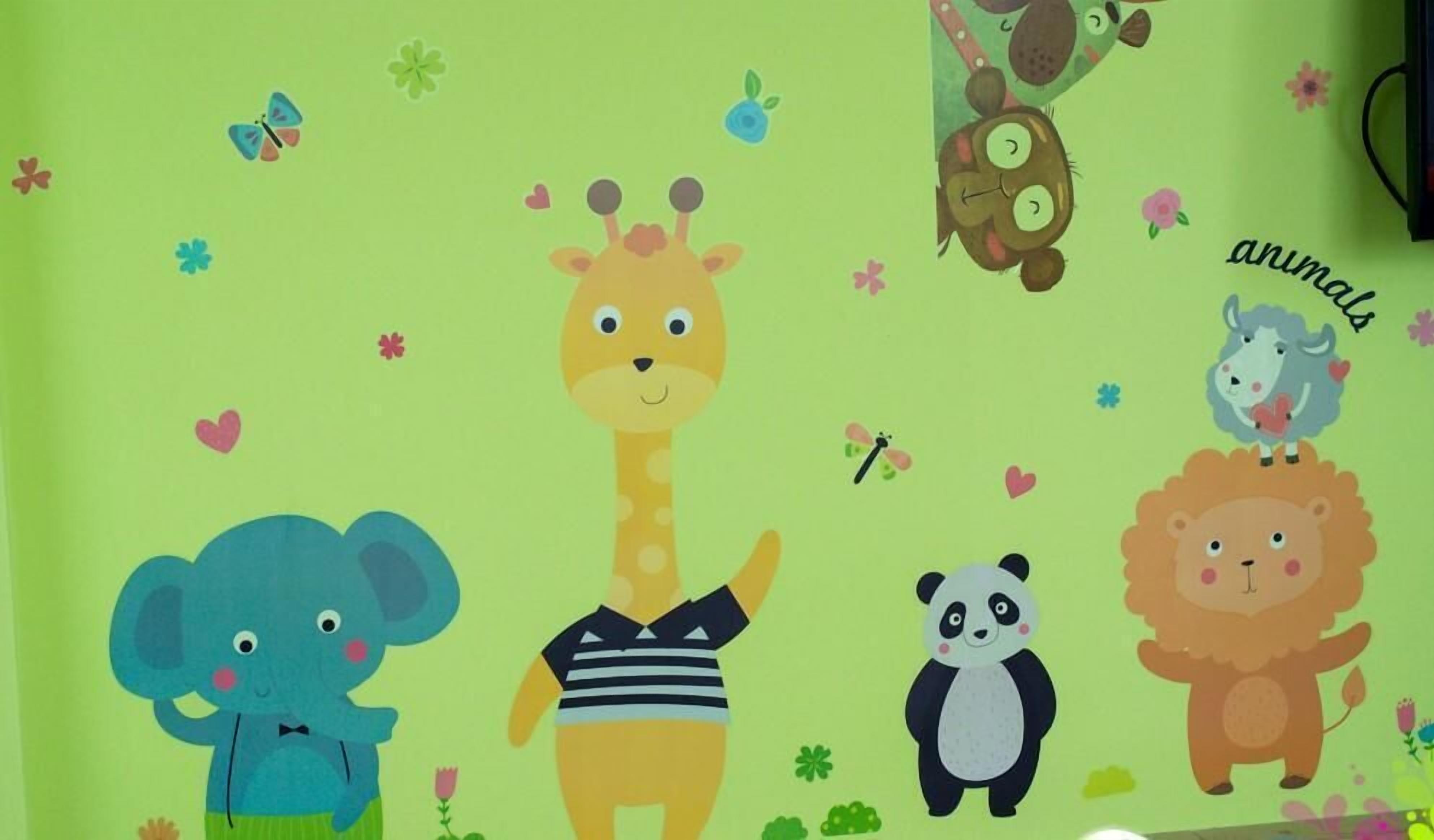 A wall with cartoon animal stickers, including a giraffe, elephant, panda, lion, and sheep.