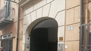 An entrance with a black door, a sign with the number 8, and a metal gate. - Al Baglio di Maqueda (Palermo)