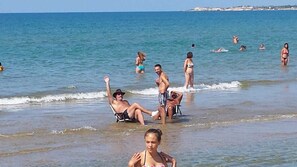 En strandscen med människor som solar och badar.