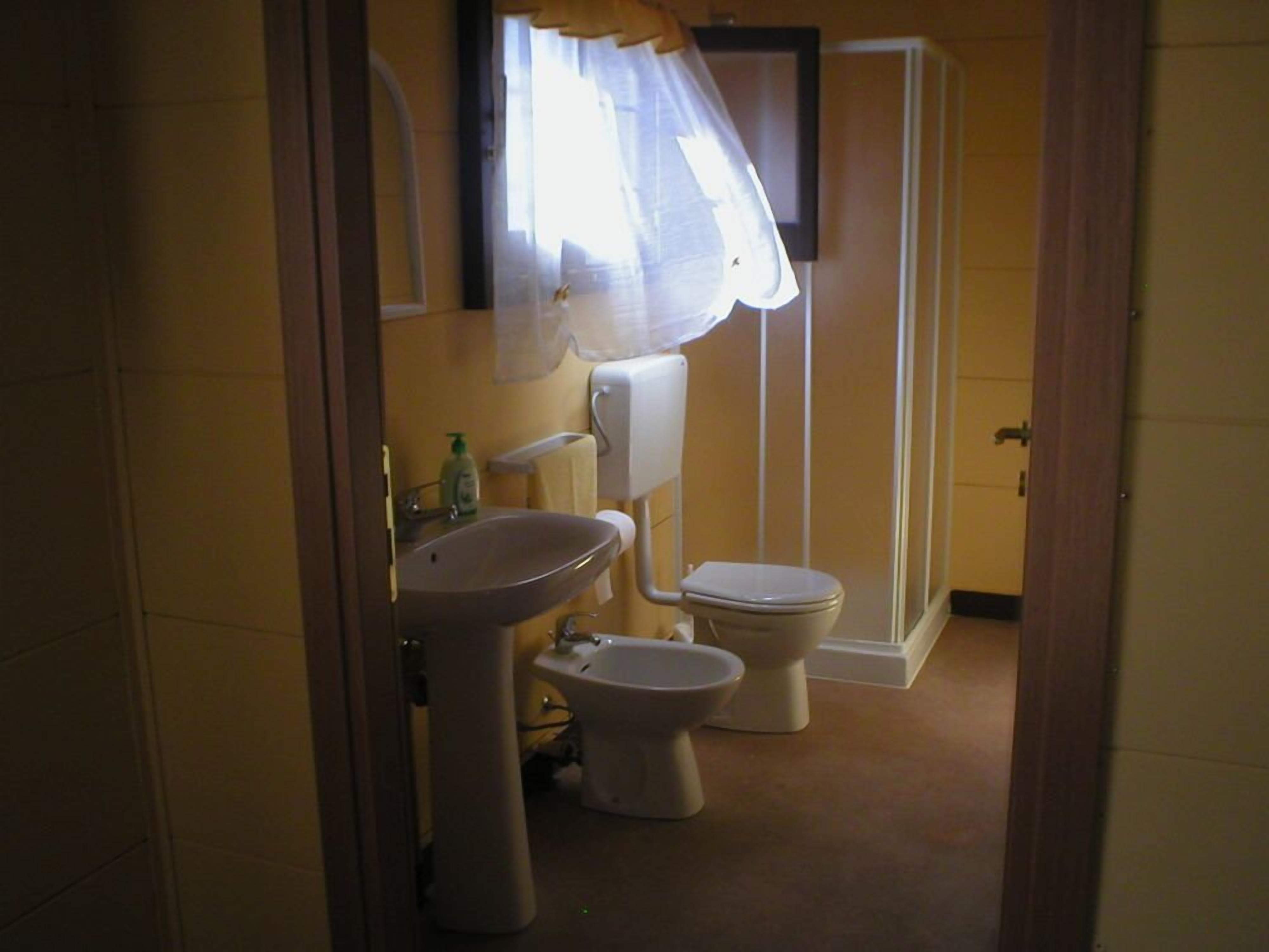 A bathroom with a sink, toilet, and bidet.