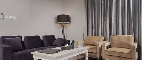 A modern living room with a sofa, armchair, and a coffee table.