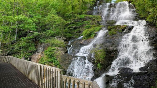 A wooden bridge leading to a waterfall surrounded by lush greenery. - Lakeside Retreat Lake Lanier-Enjoy fall with amazing hiking and wineries! (Dawsonville)