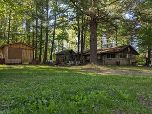 A rustic cabin with a wooden exterior, surrounded by a forest.