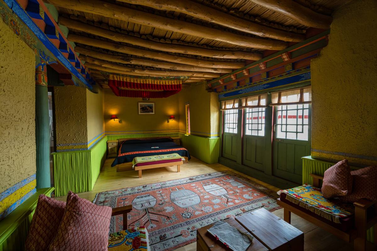 A traditional room with a bed, a bench, and a table.