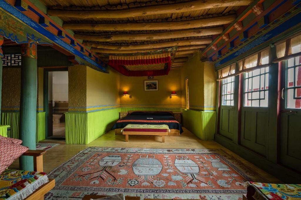 Une chambre traditionnelle avec un lit, un tapis et un plafond en bois.