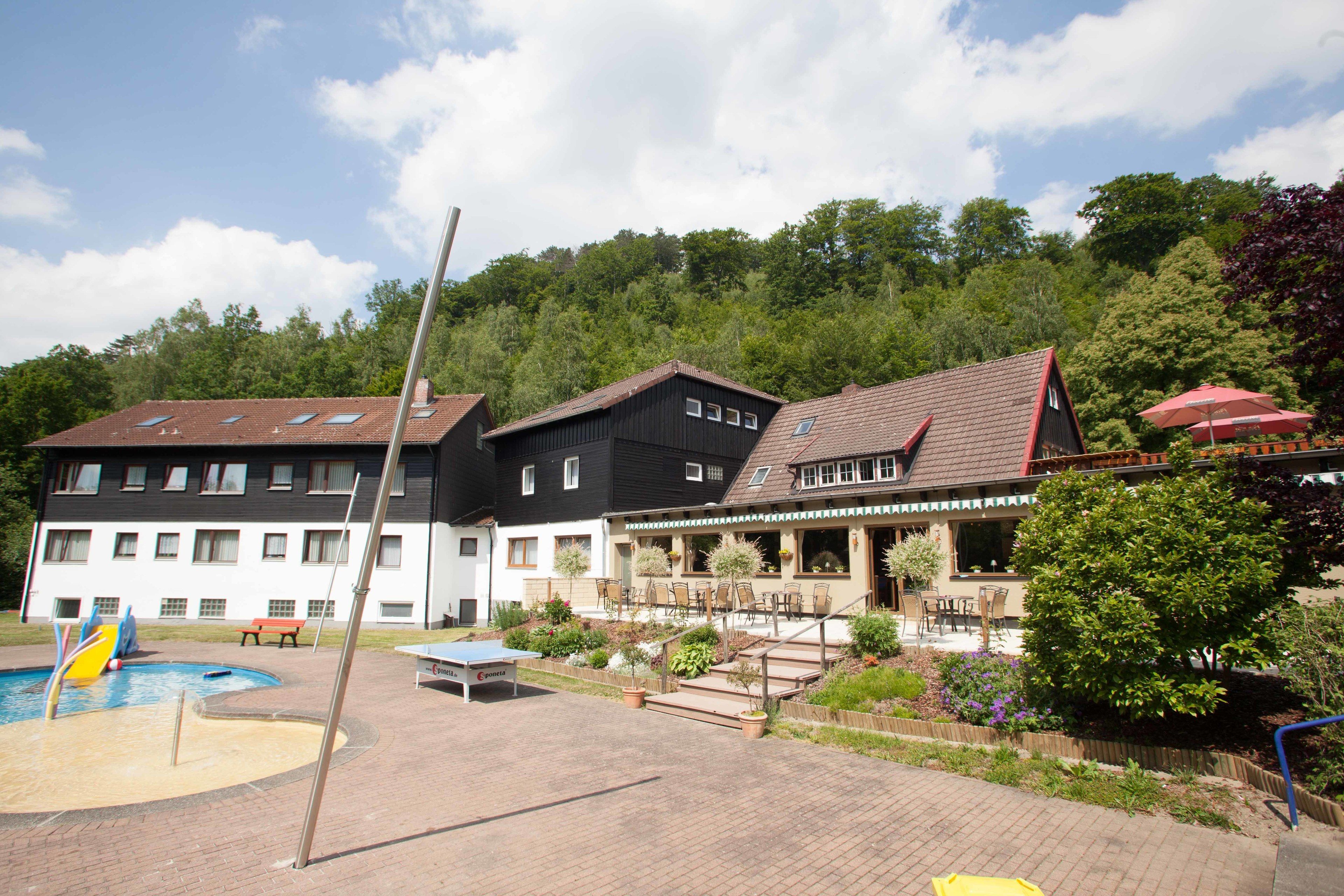 A hotel with multiple buildings, a swimming pool, and outdoor seating areas.