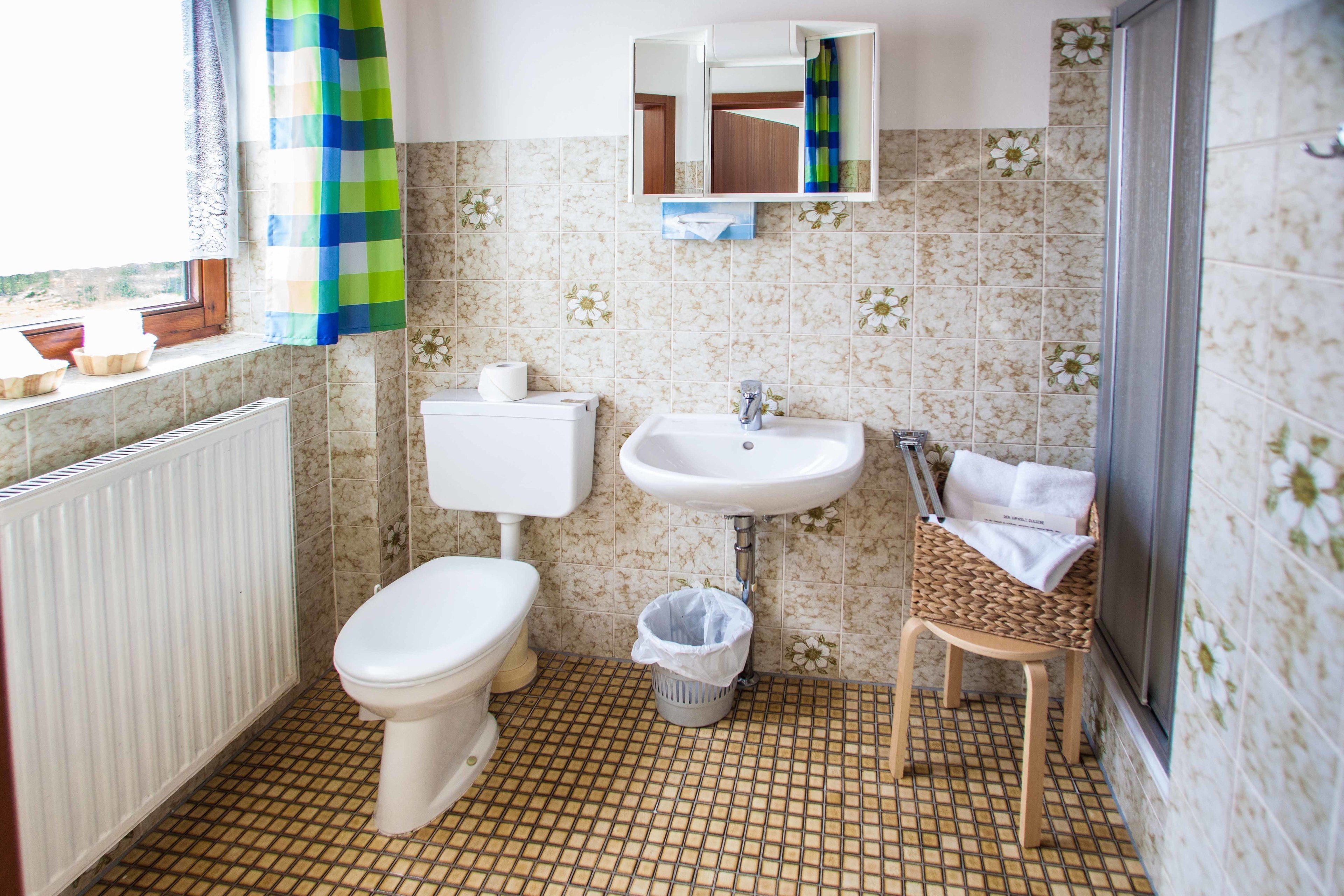 Une salle de bain comprenant des toilettes, un lavabo et un espace douche.