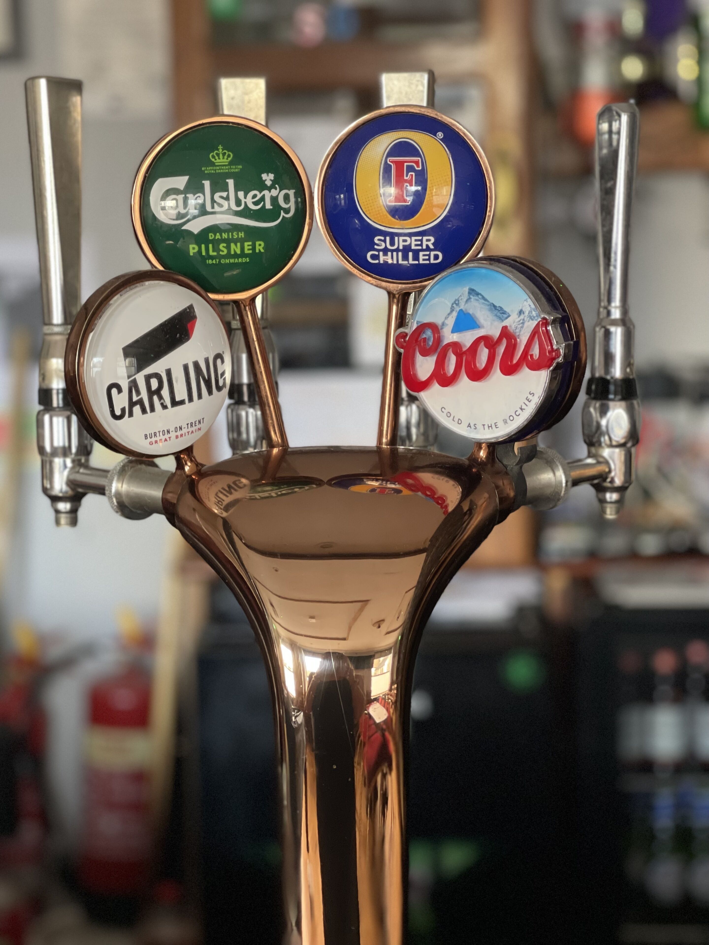 A beer tap with four different brands: Carling, Guinness, Coors, and F Super Chilled.