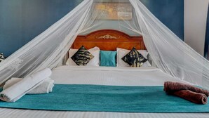 A bed with a canopy, pillows, a blanket, and towels. - Mahinder Inn By Sapphire Stays (Mahabaleshwar)