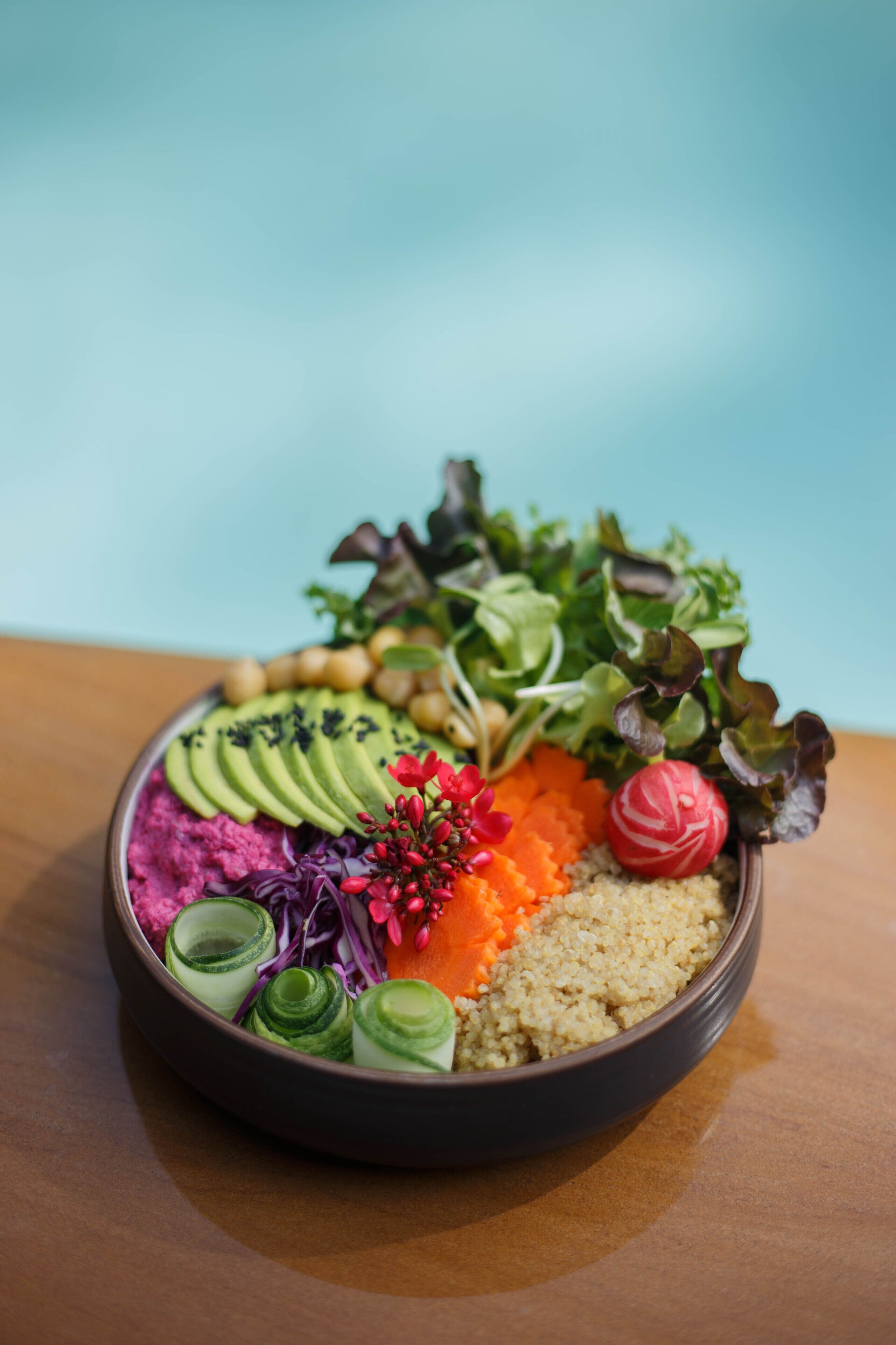 Un pasto colorato in stile bento con diverse verdure, cereali e guarnizioni.
