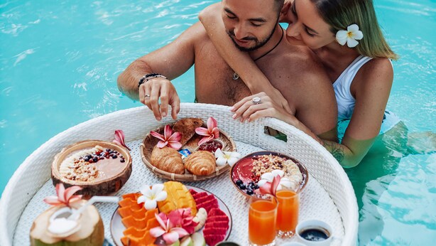 A couple in a pool with a floating tray of food and drinks. - Roost Glamping (Rawai)