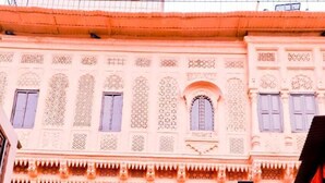 A traditional building with ornate architectural details, including a balcony with lattice work and a decorative entrance. - Singhvi's Haveli (Jodhpur)