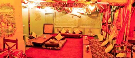 A room with a red carpet, wooden furniture, and a traditional decor style.