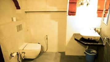 A compact bathroom with a toilet, sink, and shower.