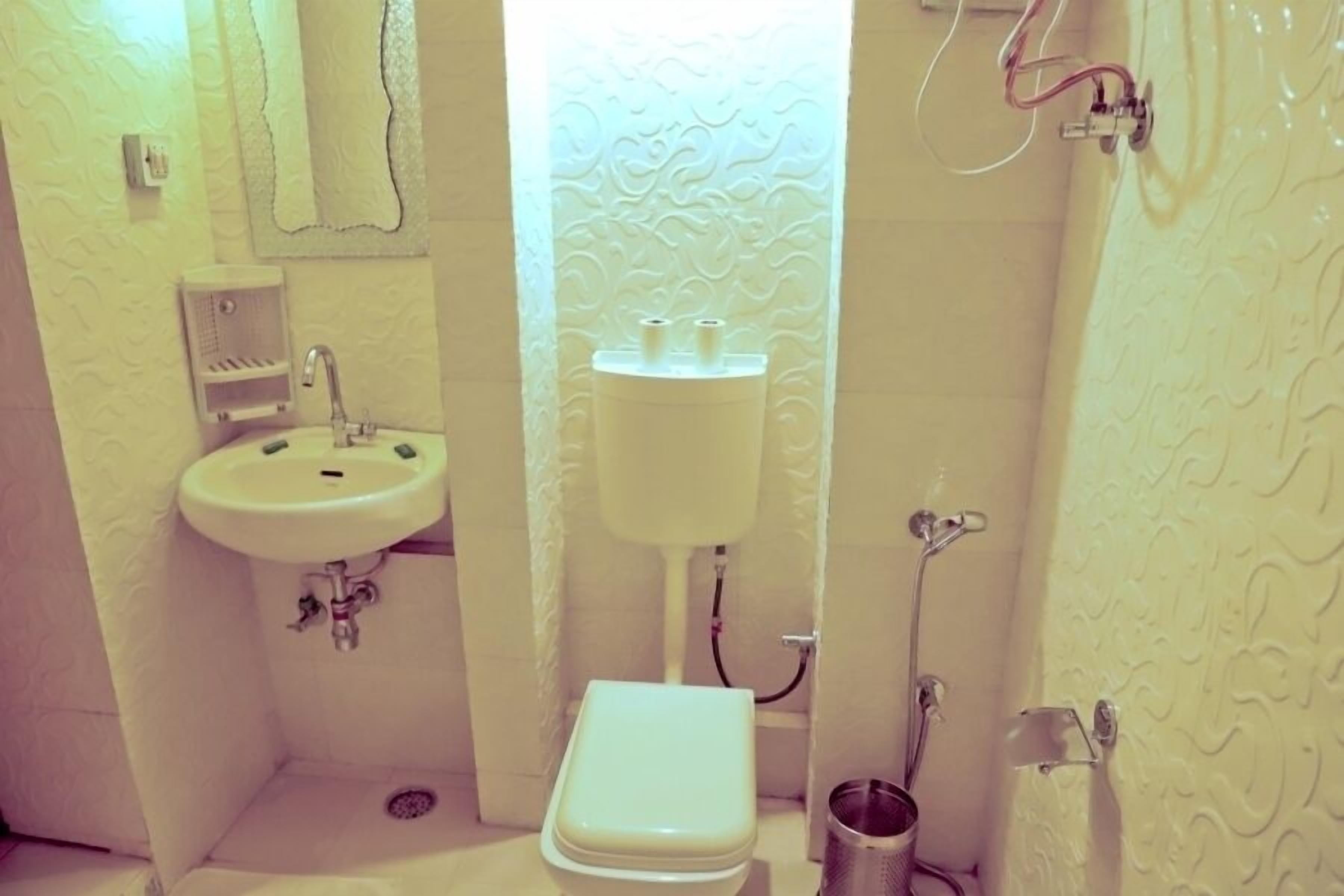 A compact bathroom with a sink, toilet, and shower.
