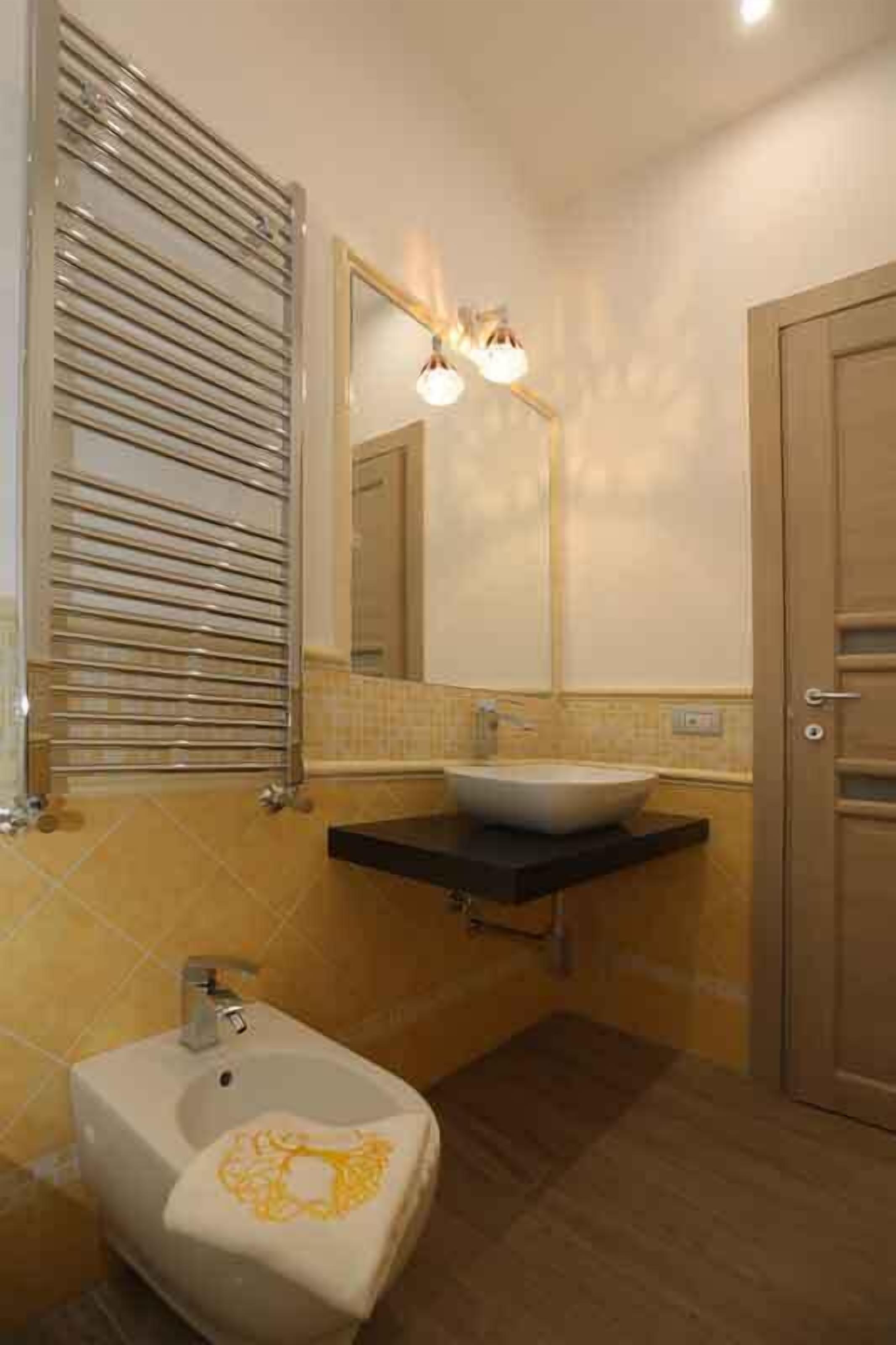 A bathroom with a sink, mirror, and towel rack.