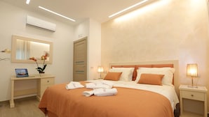 A hotel room with a large bed, bedside lamps, a desk with a laptop, and a mirror. - Relais Ohana (Vico Equense)