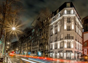 A multi-story building with a classic architectural style, featuring balconies and large windows. - Hotel Bridget (Paris)