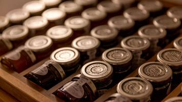 A wooden tray with multiple jars of preserves.