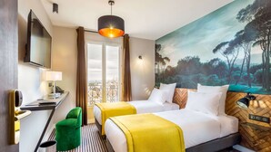 A hotel room with two beds, a desk, a TV, a painting, and a view of the outdoors. - Hotel Bridget (Paris)