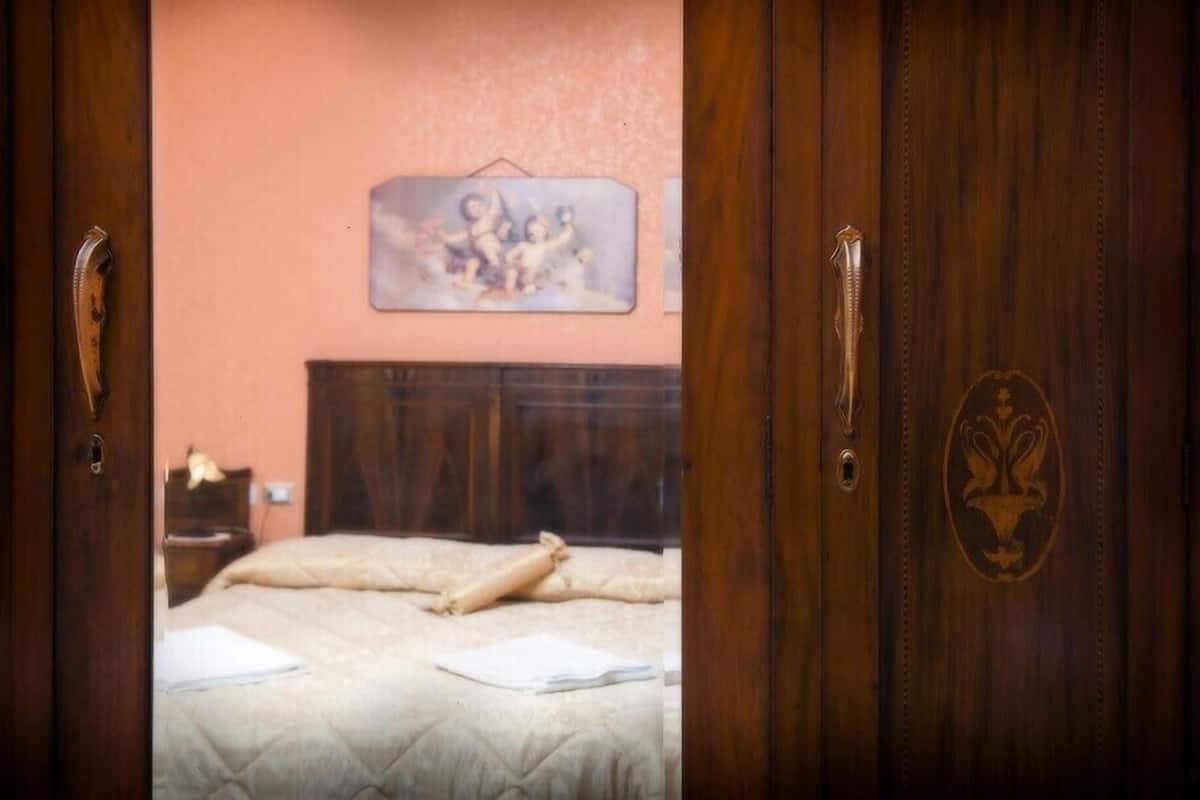A bedroom with a bed, a nightstand, and a wall-mounted picture.