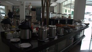 A buffet setup with various food containers and utensils. - Xingu Praia Hotel (Altamira)