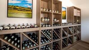 A wine cellar with wooden shelves and racks holding wine bottles. - L'Orée du Bois Bourgogne - Adults Only (Saint-Nicolas-lès-Cîteaux)