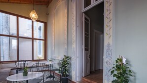Comedor con mesa y sillas, plantas en macetas y piso estampado.