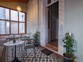 Comedor con mesa y sillas, plantas en macetas y piso estampado.