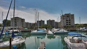 A marina with several boats docked, surrounded by multi-story buildings. - Residence Porta del Mare (Lignano Sabbiadoro)