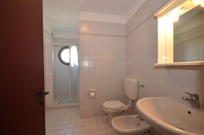 A bathroom with a toilet, bidet, and sink.