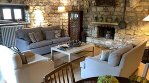 A cozy living room with a stone fireplace, a sofa set, and a coffee table.