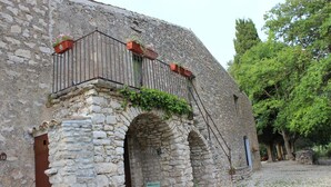 A stone building with a balcony, a door, and a small table with chairs. - Villa Misita (Prizzi)
