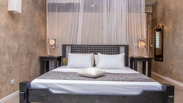 Ein Bett mit Baldachin, zwei Nachttische und ein Spiegel an der Wand.