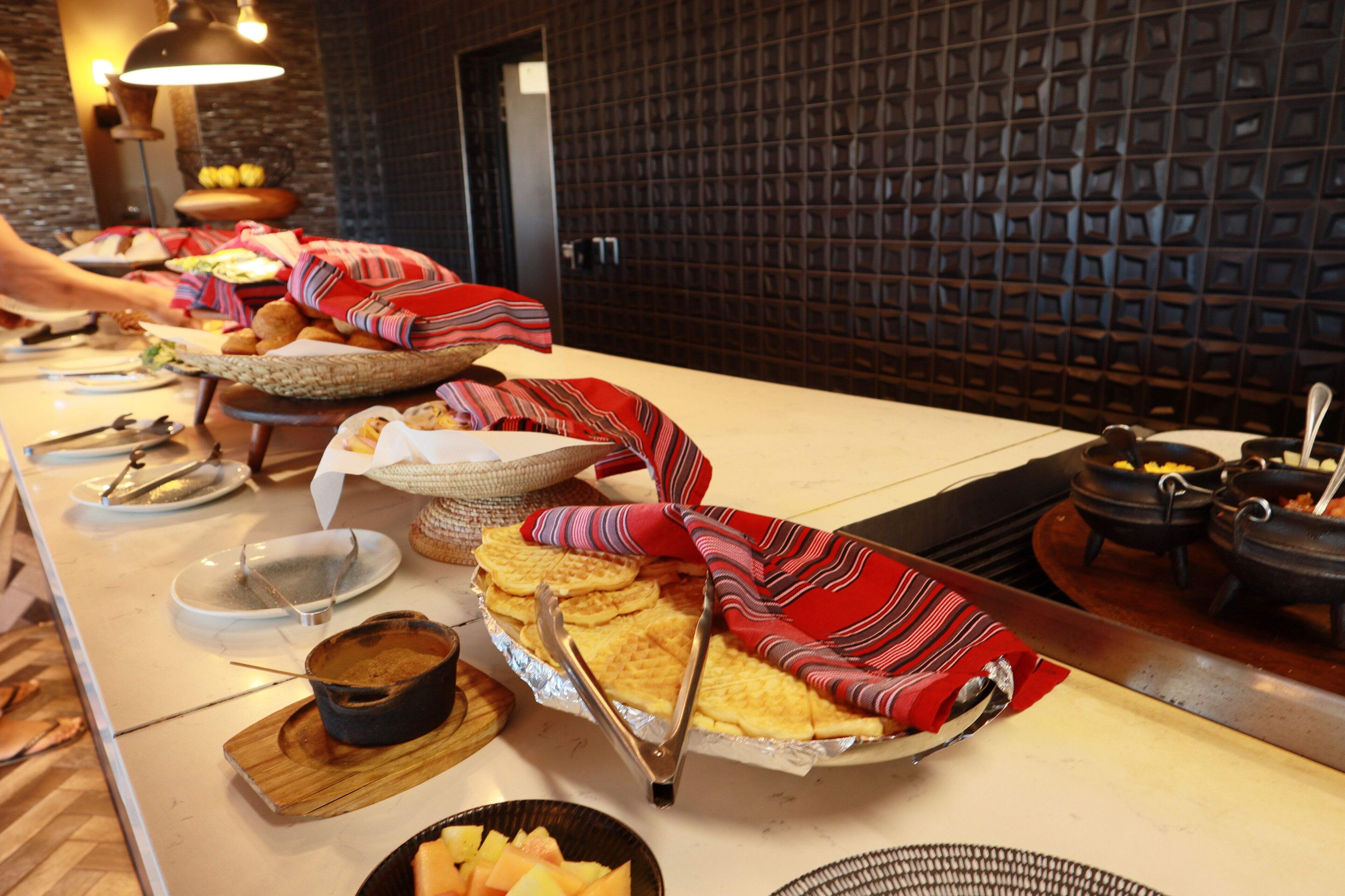 A buffet setup with various food items and serving utensils.