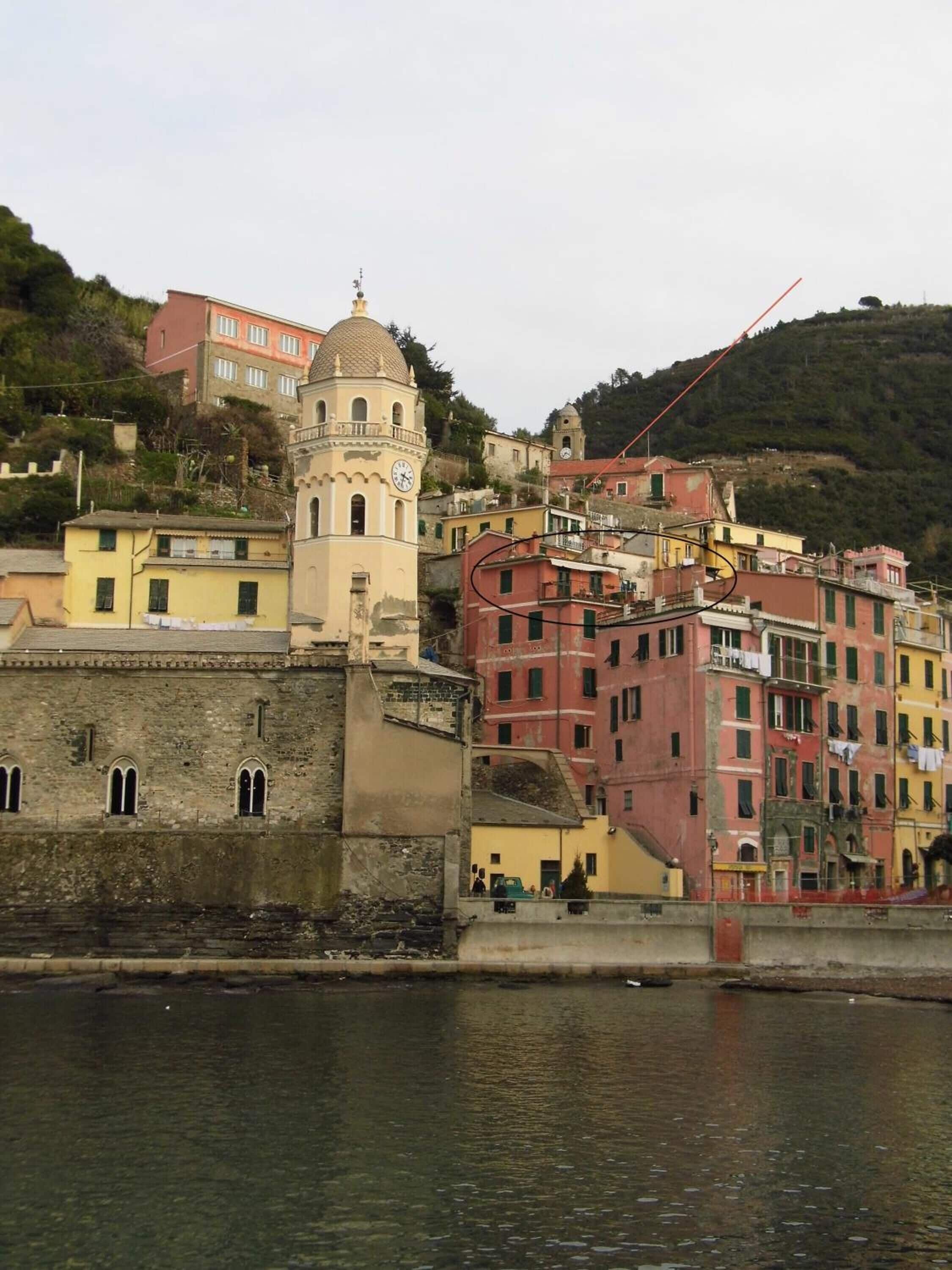 A coastal town with historic buildings, a prominent clock tower, and a river.