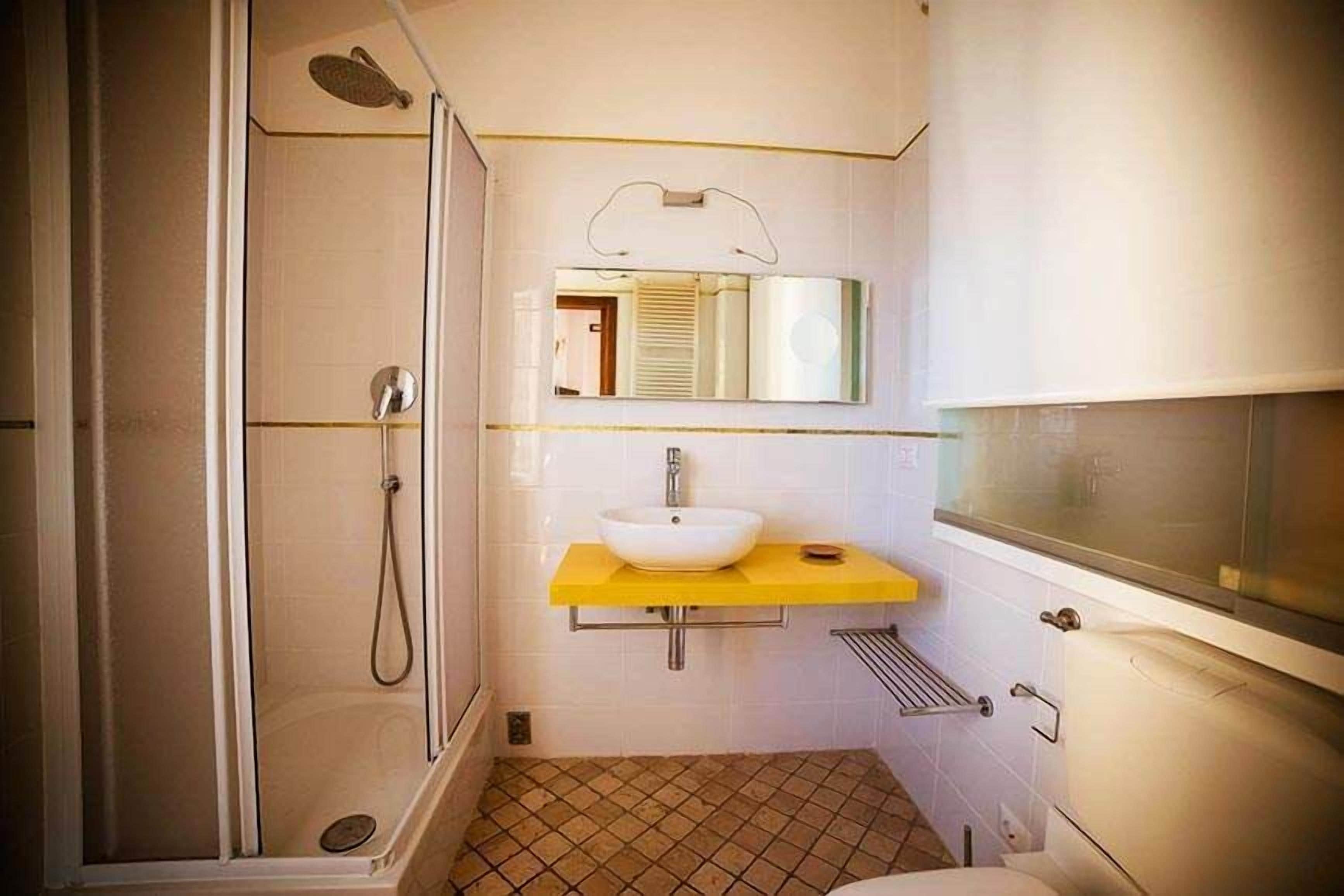 Een badkamer met een douche, wastafel en toilet.