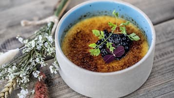 Un bol de soupe, agrémenté d’une garniture, posé sur une surface en bois.