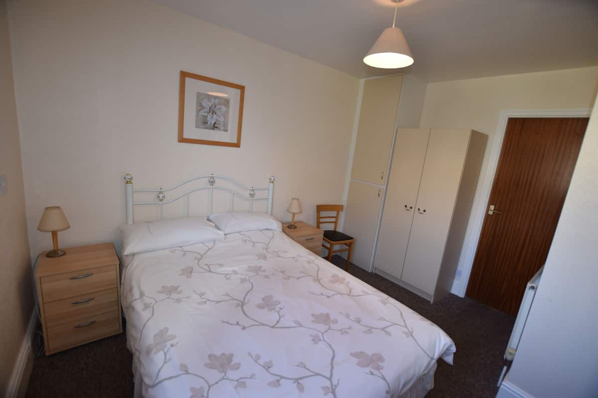 Tabla de planchar con plancha y ropa de cama