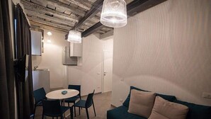 Una cocina moderna con comedor, sofá e iluminación colgante.