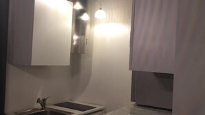 Una cocina moderna con un lavamanos integrado, una encimera e iluminación colgante.