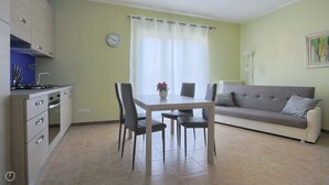 A compact living space with a kitchenette, dining area, and a sofa. - Italianway - Casasco 79 (Centro Valle Intelvi)
