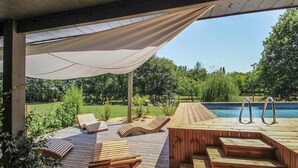 A wooden deck with lounge chairs and a pool. - Villa Maya Uma (Vendays-Montalivet)
