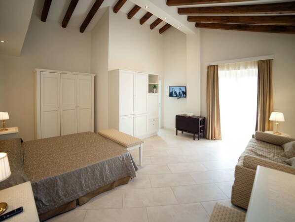 A spacious bedroom with a large bed, a sofa, a TV, and a wardrobe. - Marina Di Savoca (Santa Teresa di Riva)