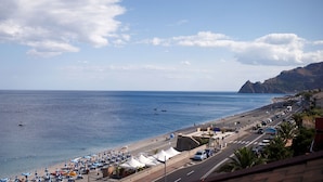 A coastal road with beachside cafes and umbrellas, a clear sky, and a mountainous backdrop. - Marina Di Savoca (Santa Teresa di Riva)