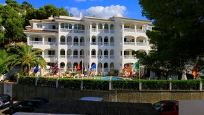 Un edificio de varios pisos con balcones y una piscina.