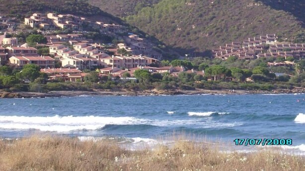A coastal village with terraced houses on a hillside, overlooking the sea. - Head of four terraced houses (Porto Corallo)