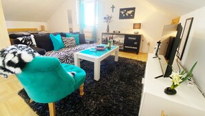 Un salon moderne avec un canapé, un fauteuil turquoise et une table basse.
